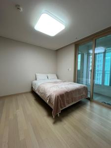a bedroom with a bed and a large window at 모이다하우스 in Incheon