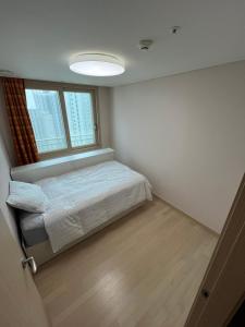 a small bedroom with a bed and a window at 모이다하우스 in Incheon