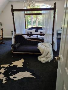 una camera con letto a baldacchino e divano di The Luxurious Manor - Very Large Bedroom with Private Ensuite ad Auckland