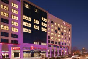 Un gran edificio con luces moradas en el frente. en Hotel Ramada Pitesti, en Piteşti
