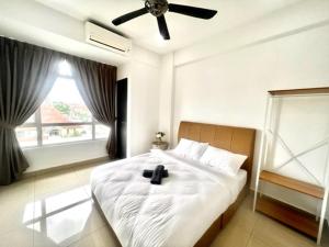 a bedroom with a bed with a black cross on it at Furusato Midori Green- Tmn Mount Austin at Johor Bahru in Johor Bahru +11 photos