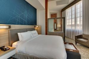 a bedroom with a large bed and a chair at SpringHill Suites by Marriott Montgomery Downtown in Montgomery +24 photos