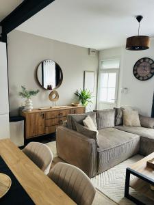 a living room with a couch and a mirror at Maison de pêcheur avec extérieur in Étaples