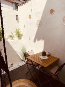 a patio with a wooden table and chairs at Maison de pêcheur avec extérieur in Étaples
