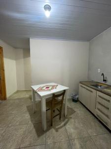 a kitchen with a white table and a sink at Casa gravata de penha in Penha