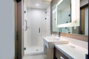 a bathroom with a sink and a shower and a mirror at SpringHill Suites by Marriott Miami Doral in Miami