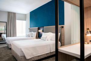 a hotel room with two beds and a blue wall at SpringHill Suites by Marriott Miami Doral in Miami