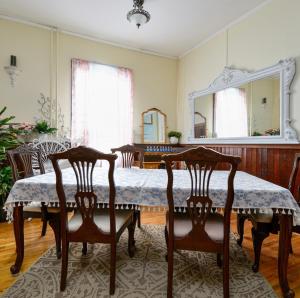 a dining room with a table with two chairs and a mirror at Royal Hotel Sydney in Sydney