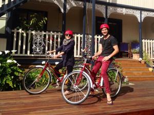 un hombre y una mujer montando bicicletas en una cubierta en Montacute Boutique Bunkhouse en Hobart