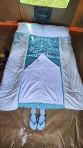 Homa BayArch-Villa Resort&Camping Site Mfangano Island的床上有被子和一双鞋