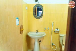 a bathroom with a sink and a toilet and a mirror at Chiller Jone's place in Tangalle