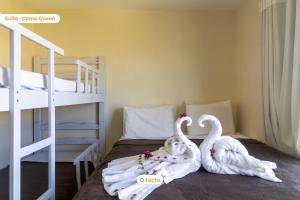 two swans towels on a bed in a bedroom at Apto no VG Sun com acesso exclusivo à praia in Paracumbuca +50 photos