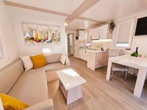 a living room with a couch and a table and a kitchen at Sea Diva - luxury boathouse in Portorož