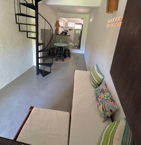 a living room with a couch and a staircase at Casa Amora in Porto Seguro