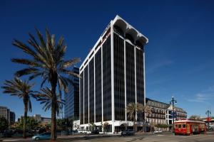 a tall building with palm trees and a red bus at TownePlace Suites by Marriott New Orleans Downtown/Canal Street in New Orleans