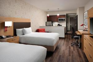 a hotel room with two beds and a kitchen at TownePlace Suites by Marriott New Orleans Downtown/Canal Street in New Orleans