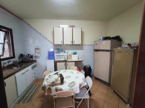 een kleine keuken met een tafel en een koelkast bij Casa Saquarema Jaconé com Piscina, 4Q in Saquarema