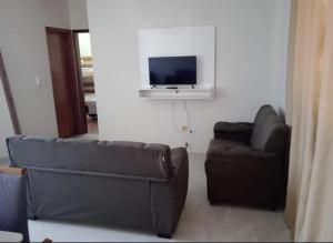 a living room with a couch and a flat screen tv at ap 22 amaryllis in Poços de Caldas