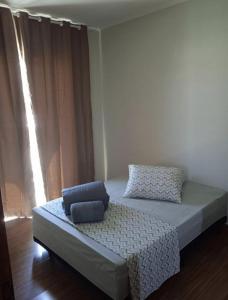 a bed with two pillows on it in a room at ap 22 amaryllis in Poços de Caldas