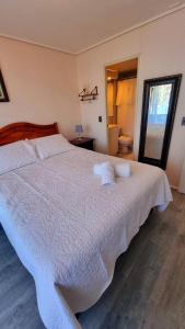 a bedroom with a large white bed with white sheets at Departamento amoblado in Temuco