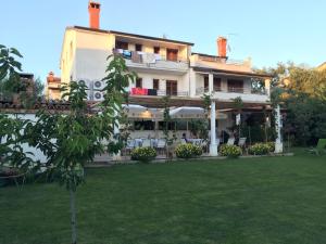 un edificio con un albero di fronte di Vera Bed and Breakfast a Umag (Umago)