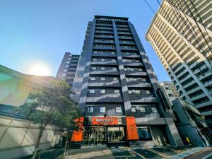 东京APA Hotel Keikyu Kamata Ekimae Nishi的城市中心的一座高楼