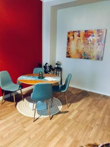 a dining room with a table and chairs and a painting at Am Pontepark in Görlitz