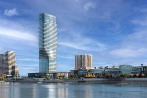a tall skyscraper in a city next to a body of water at The St. Regis Belgrade in Belgrade