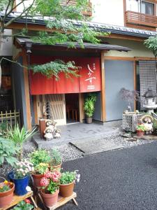 京都的住宿－清水日式旅館，前面有盆栽植物的建筑