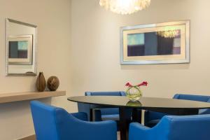 a dining room with a table and blue chairs at Le Royal Meridien Abu Dhabi in Abu Dhabi