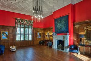 a large room with red walls and a fireplace at Le Meridien Dallas, The Stoneleigh in Dallas