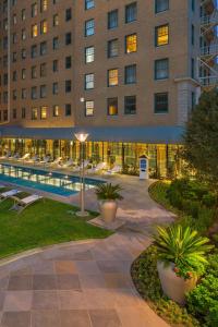 a hotel with a pool in front of a building at Le Meridien Dallas, The Stoneleigh in Dallas