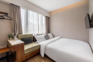 Postel nebo postele na pokoji v ubytování Shanghai Meego Qingwen Hotel