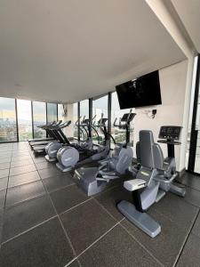 a gym with cardio equipment in a building with windows at Apartment with city views central area in Guadalajara
