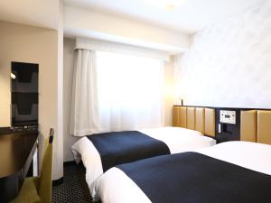 Postel nebo postele na pokoji v ubytování APA Hotel Iidabashi Ekimae