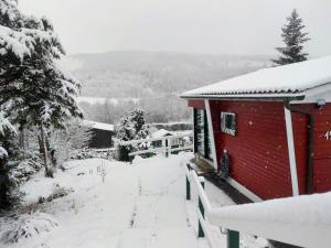 a red house with snow on the roof at Ferienhaus Bergblick Urlaub mit Hund in Meschede