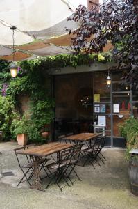 twee houten tafels en stoelen voor een gebouw bij Ca la Flora in Banyoles