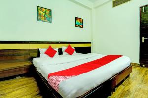 a bedroom with a bed with a red and white blanket at Super Hotel O Sunshin Deluxe in Nagpur +25 photos