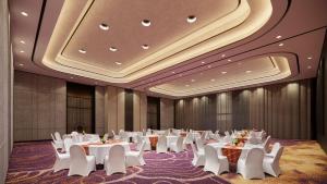 una sala banchetti con tavoli bianchi e sedie bianche di Mercure Madiun a Madiun Altre 30 foto