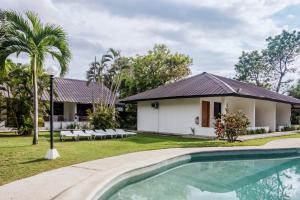 a villa with a swimming pool in front of a house at Go Resort in Bauang