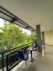 a balcony with chairs and a table and trees at Wisma HN in Selang