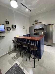 eine Küche mit einer Bar mit Stühlen und einem Kühlschrank in der Unterkunft Saphira House Beach in Porto Belo
