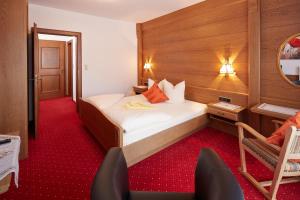 ein Hotelzimmer mit einem Bett und einem Stuhl darin in der Unterkunft Alpenmotel Säuling in Reutte