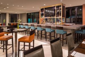 a bar in a restaurant with chairs and tables at Sheraton Dallas Hotel by the Galleria in Dallas
