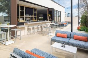an outdoor patio with couches and tables and a bar at Sheraton Dallas Hotel by the Galleria in Dallas