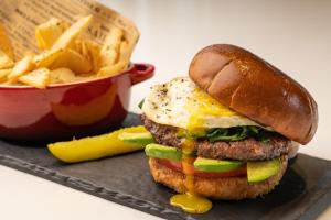 a hamburger with an egg on a bun and fries at Sheraton Dallas Hotel by the Galleria in Dallas