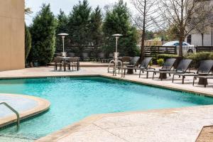 a swimming pool with chairs and a table and chairs at Sheraton Dallas Hotel by the Galleria in Dallas