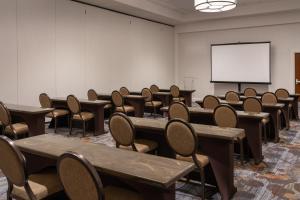 a conference room with tables and chairs and a white screen at Sheraton Dallas Hotel by the Galleria in Dallas