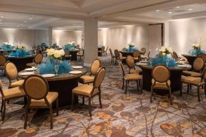 a banquet room with tables and chairs with blue flowers at Sheraton Dallas Hotel by the Galleria in Dallas