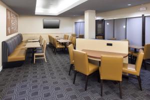una sala da pranzo con tavoli, sedie e TV di TownePlace Suites Columbia Southeast / Fort Jackson a Columbia Altre 25 foto